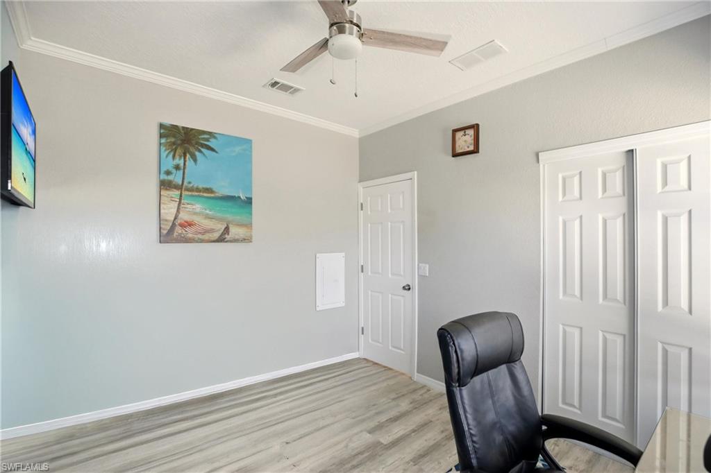 Office with ornamental molding, wood finished floors, and ceiling fan