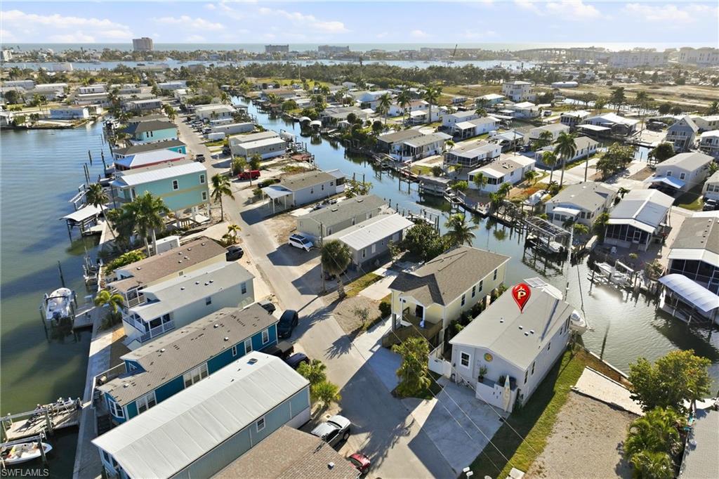 Aerial view of property and surrounding area featuring a nearby body of water and nearby suburban area