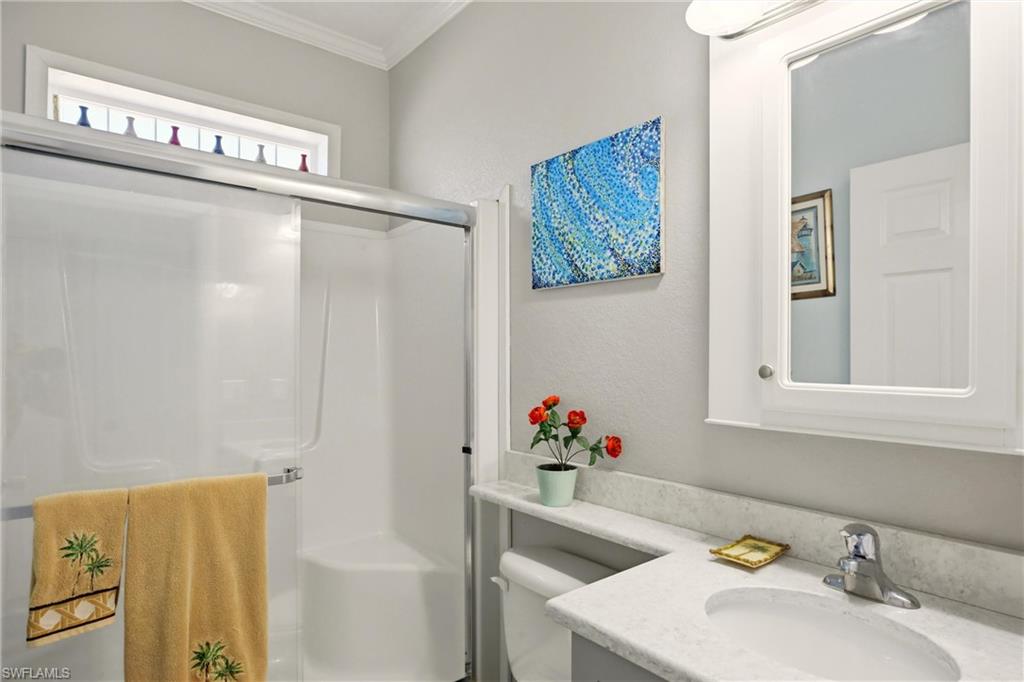 Bathroom with vanity, a stall shower, ornamental molding, and a textured wall