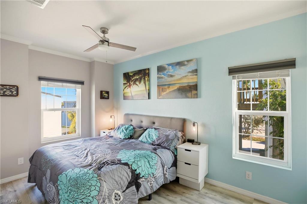 Bedroom featuring wood finished floors, ceiling fan, and ornamental molding