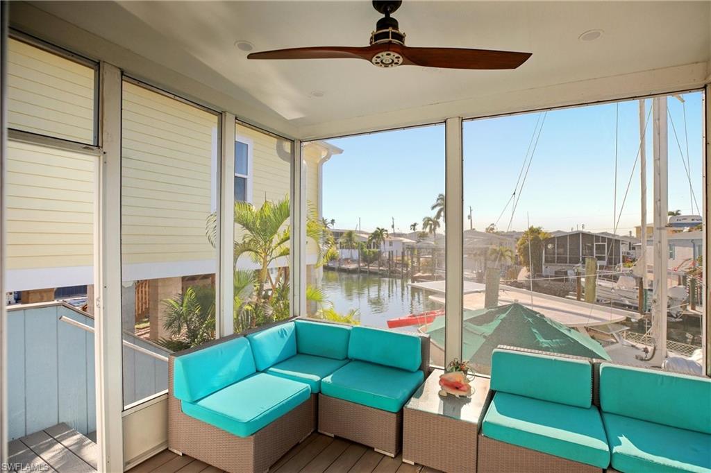 Sunroom / solarium featuring an outdoor hangout area, ceiling fan, a water view, and a residential view
