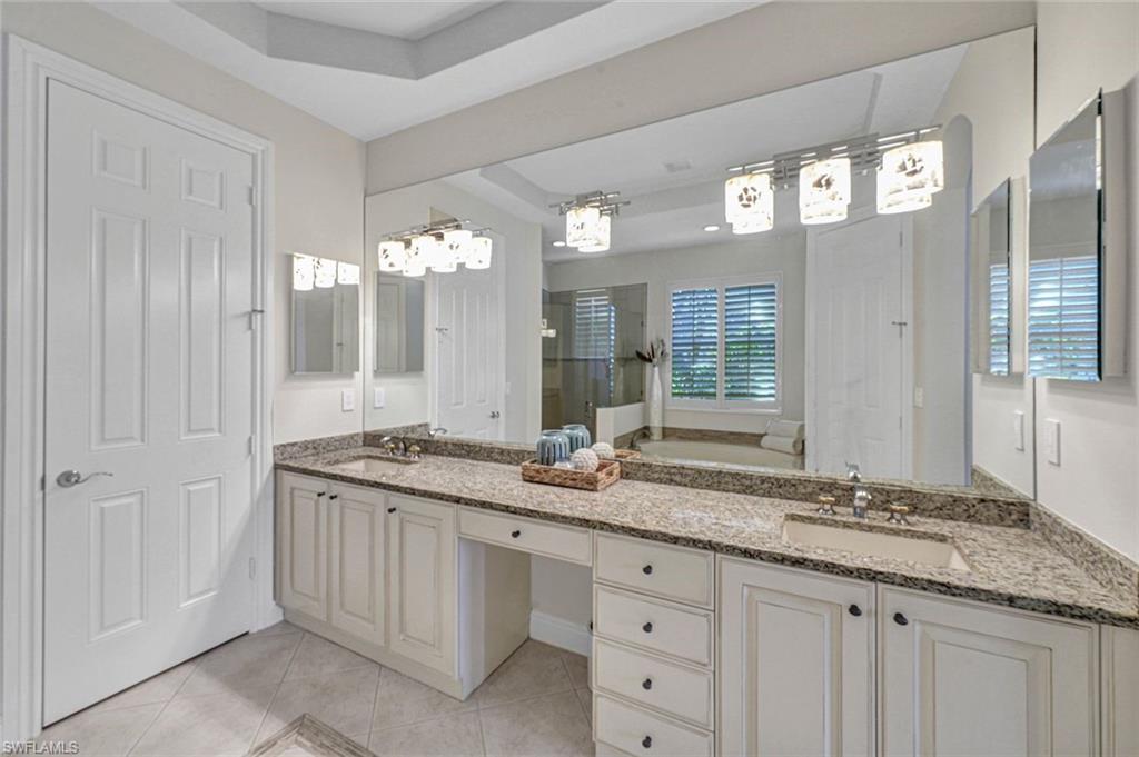 Bathroom with tile patterned flooring, a raised ceiling, vanity, and independent shower and bath