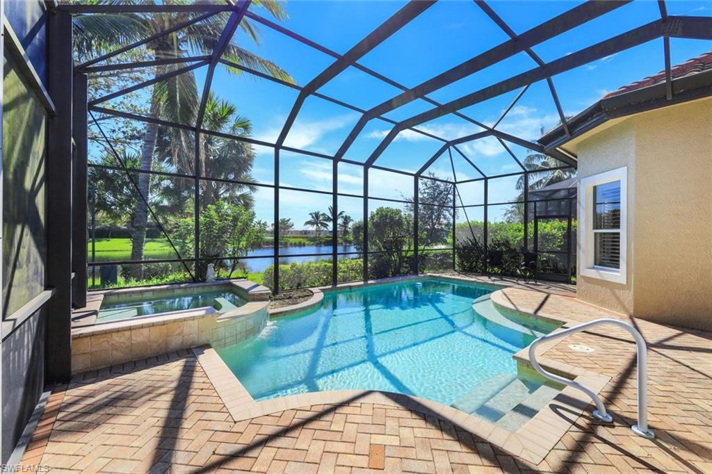 View of swimming pool featuring an in ground hot tub, a patio, and a lanai