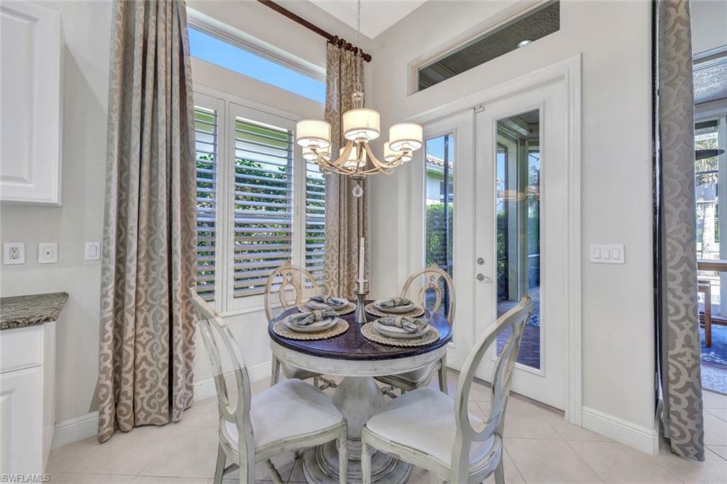 Tiled dining room with an inviting chandelier and french doors