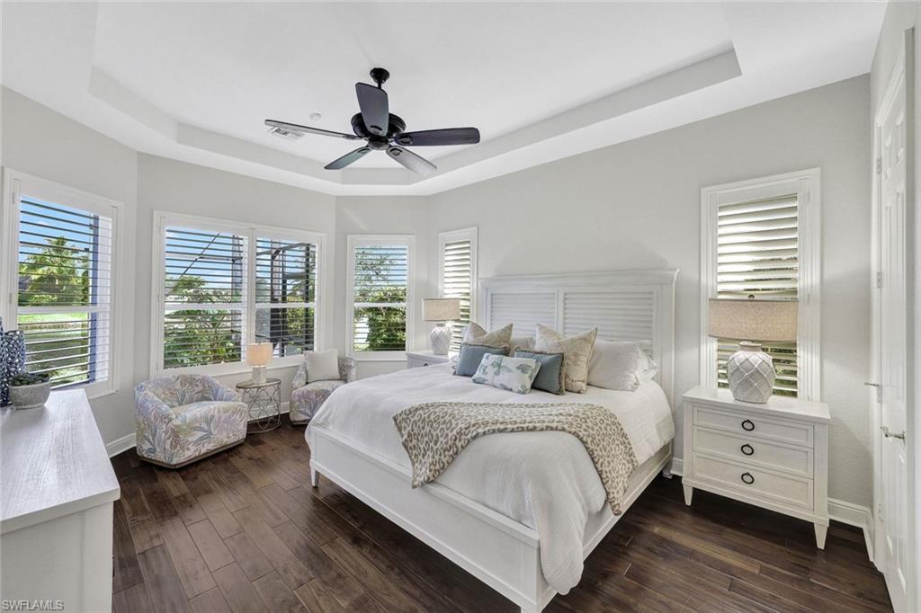 Bedroom featuring a tray ceiling, ceiling fan, and dark hardwood / wood-style floors