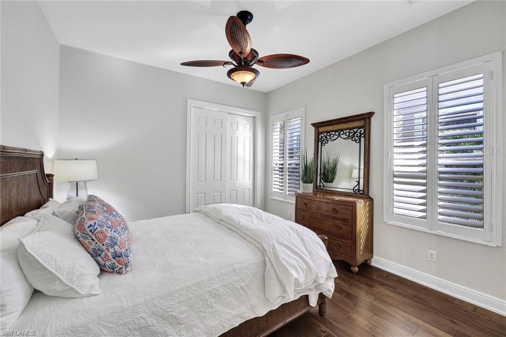 Bedroom featuring ceiling fan, dark hardwood / wood-style floors, and a closet
