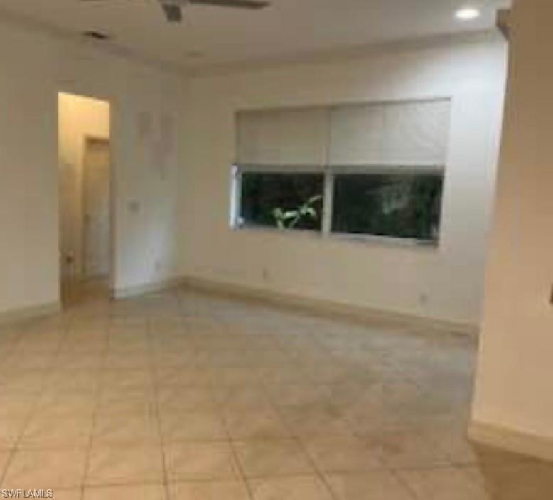Spare room featuring light tile patterned floors and a ceiling fan