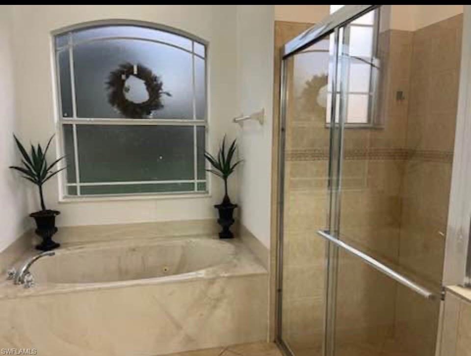 Bathroom with a shower stall and a bath