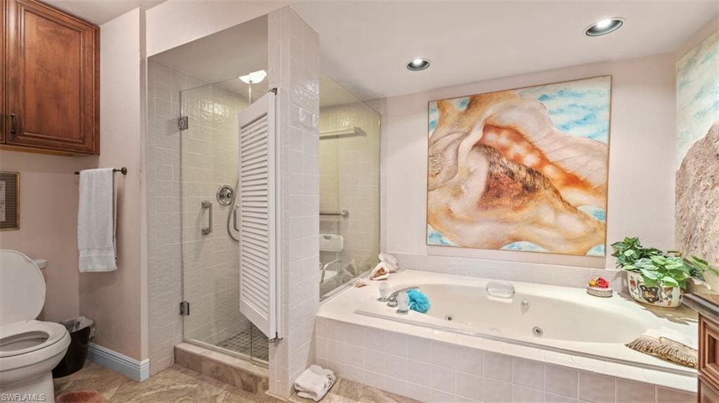 Full bathroom featuring a jetted tub, a shower stall, and recessed lighting