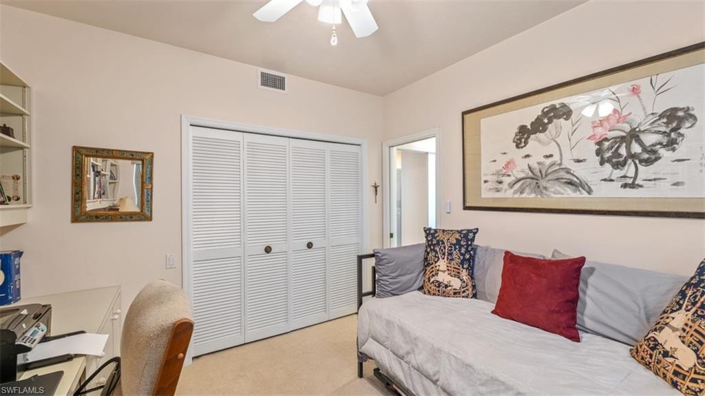 Guest Bedroom (2) featuring a closet, light colored carpet, ceiling fan, and an office area