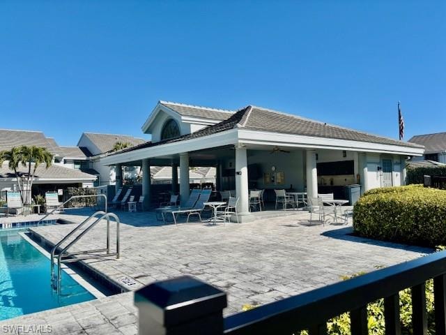 Rear view of property featuring a community pool, a patio area, and ceiling fan