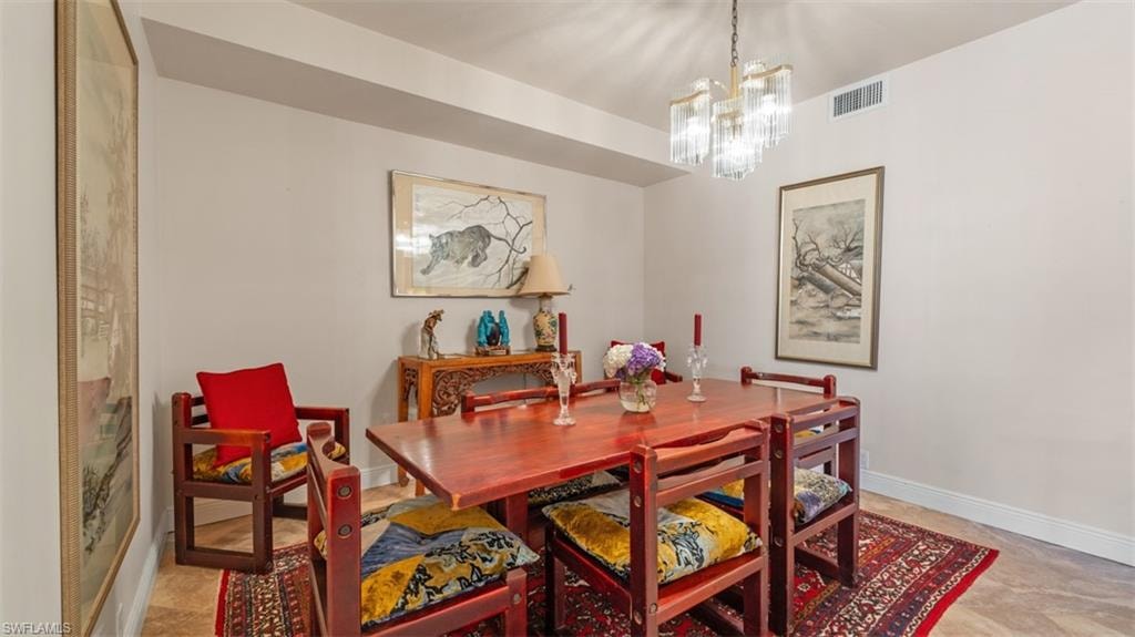 Dining area featuring baseboards and a chandelier