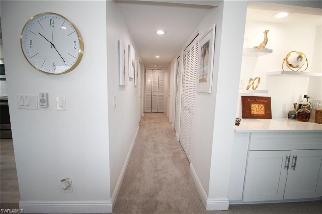 Hallway featuring light colored carpet and recessed lighting