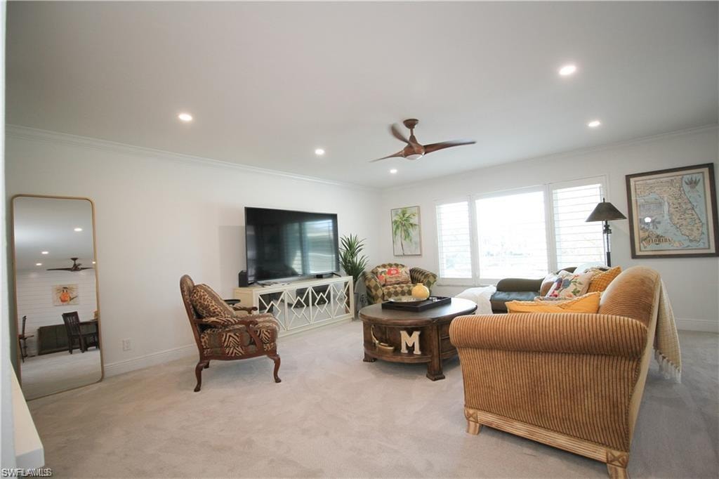 Carpeted living room with a ceiling fan, ornamental molding, and recessed lighting