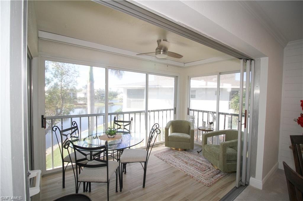 Sunroom / solarium featuring ornamental molding, healthy amount of natural light, and a water view
