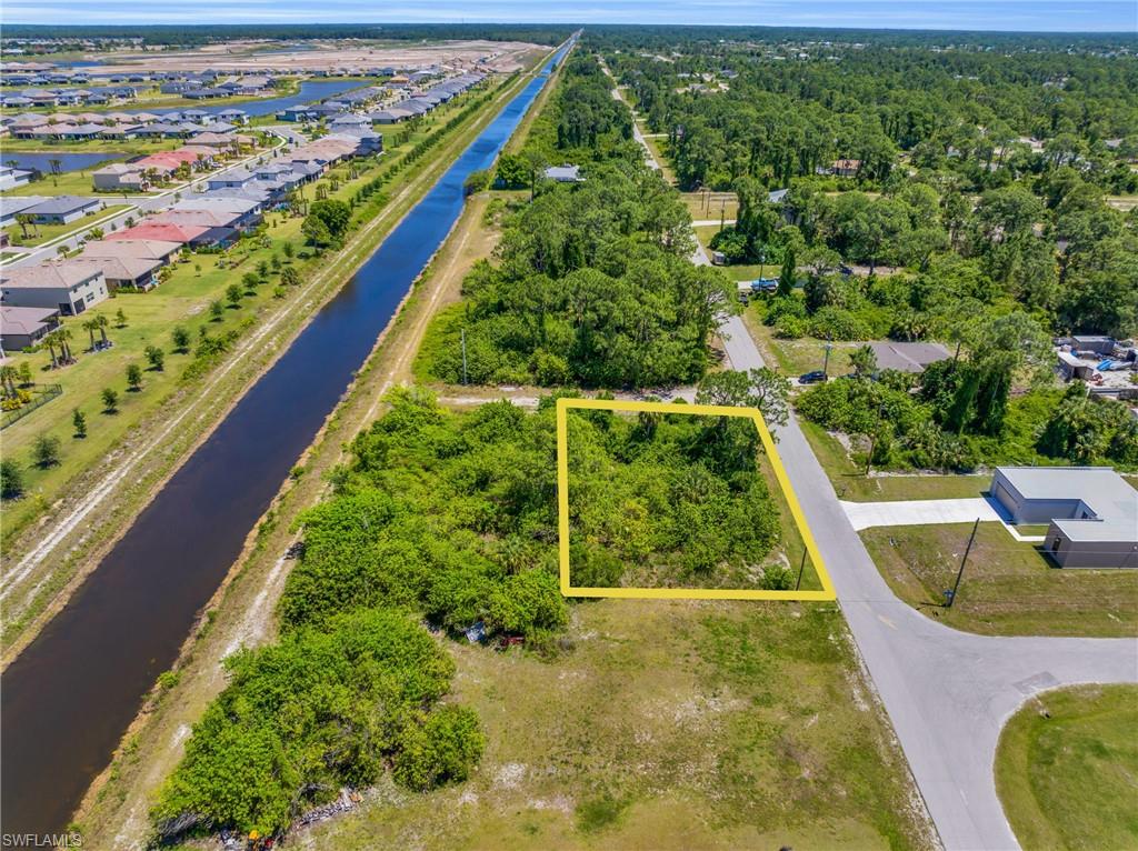 Aerial perspective of suburban area with property parcel outlined and a large body of water