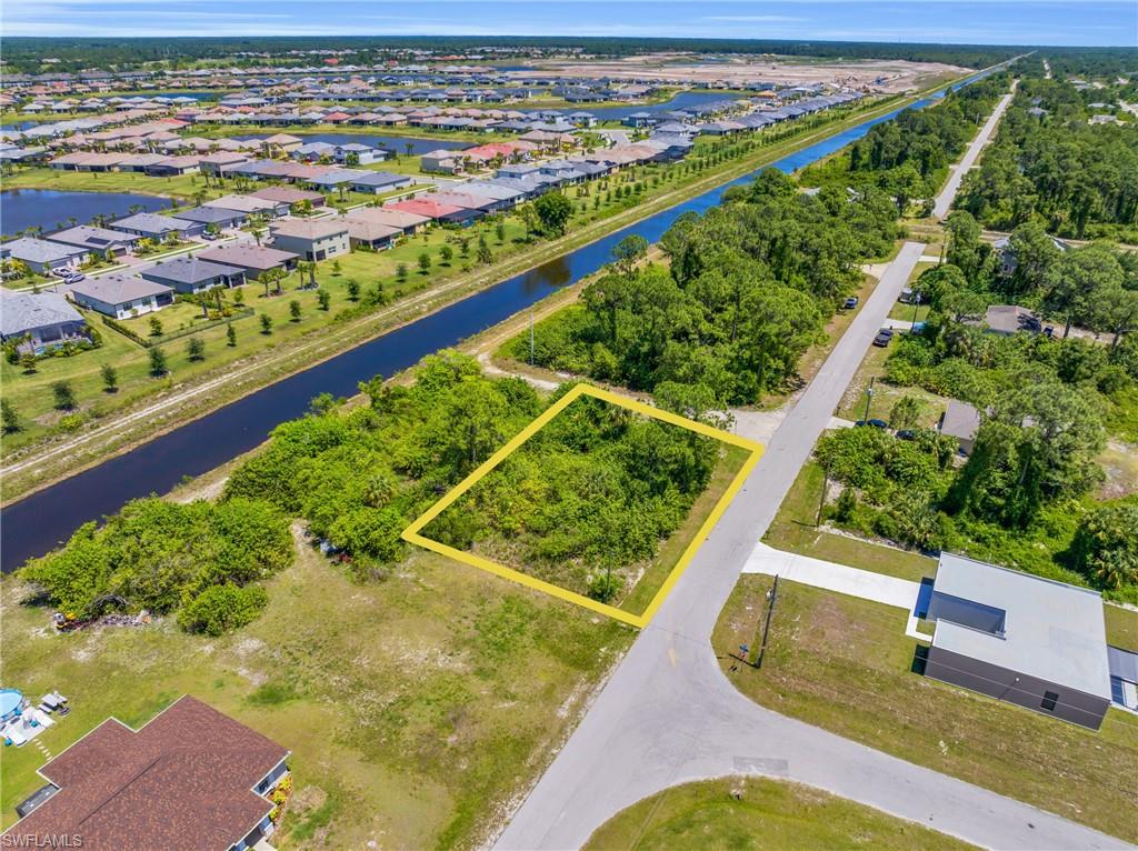 Aerial perspective of suburban area with property boundaries highlighted and a large body of water