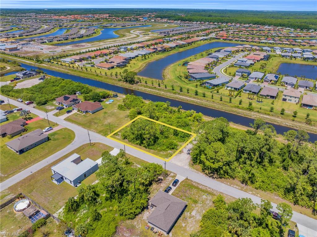 Aerial view of residential area with a large body of water and property parcel outlined