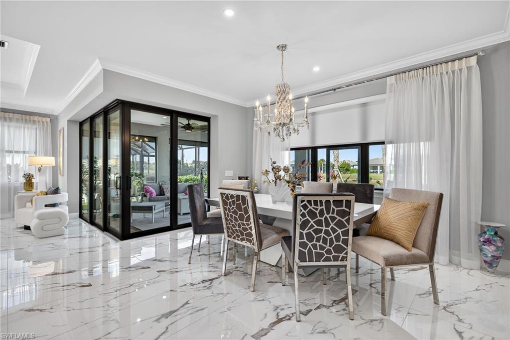 Dining space with plenty of natural light, crown molding, a chandelier, recessed lighting, and a ceiling fan