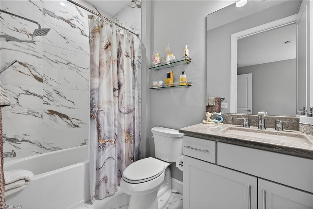 Full bath featuring shower / bath combo and vanity