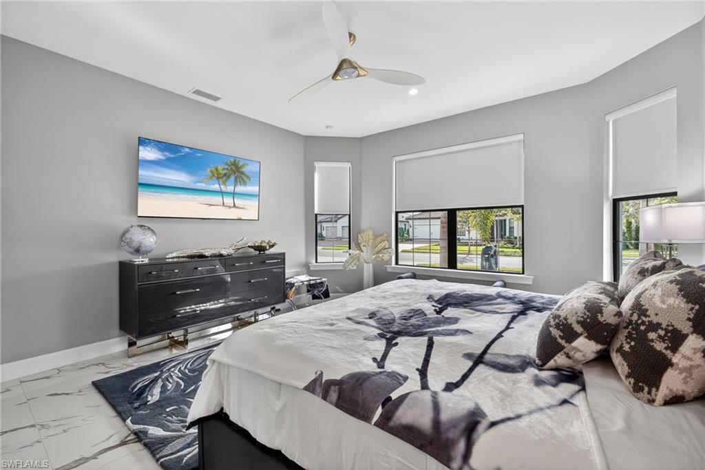 Bedroom featuring marble look tiles and a ceiling fan