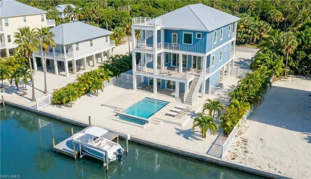 Rear 3D rendering of house with pool area, expansive decks & multiple levels, gulf access canal - virtually enhanced