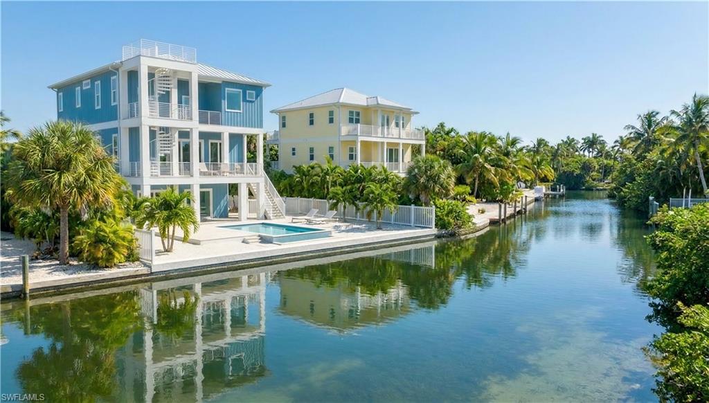 Rear 3D rendering of house with pool area, expansive decks & multiple levels, gulf access canal - virtually enhanced