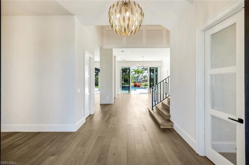 Foyer entrance with a chandelier, dark wood-type flooring, and a high ceiling