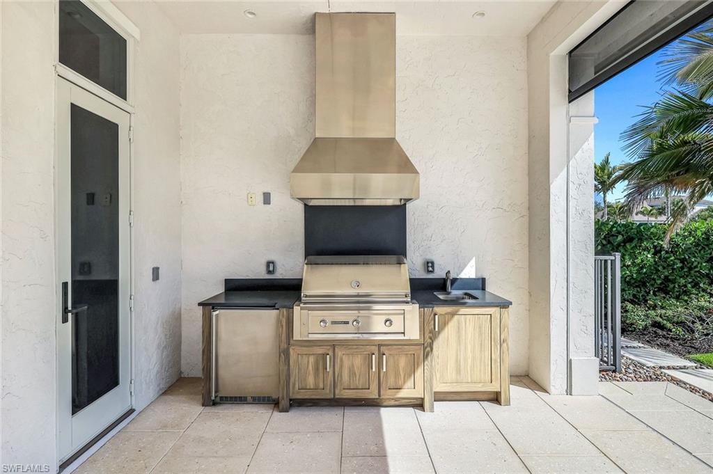 View of patio with an outdoor kitchen and a sink