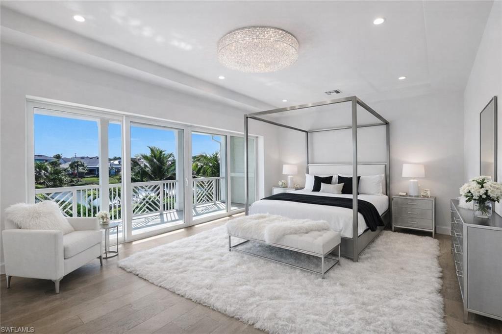 Bedroom with access to exterior, light wood-style flooring, and hanging lights