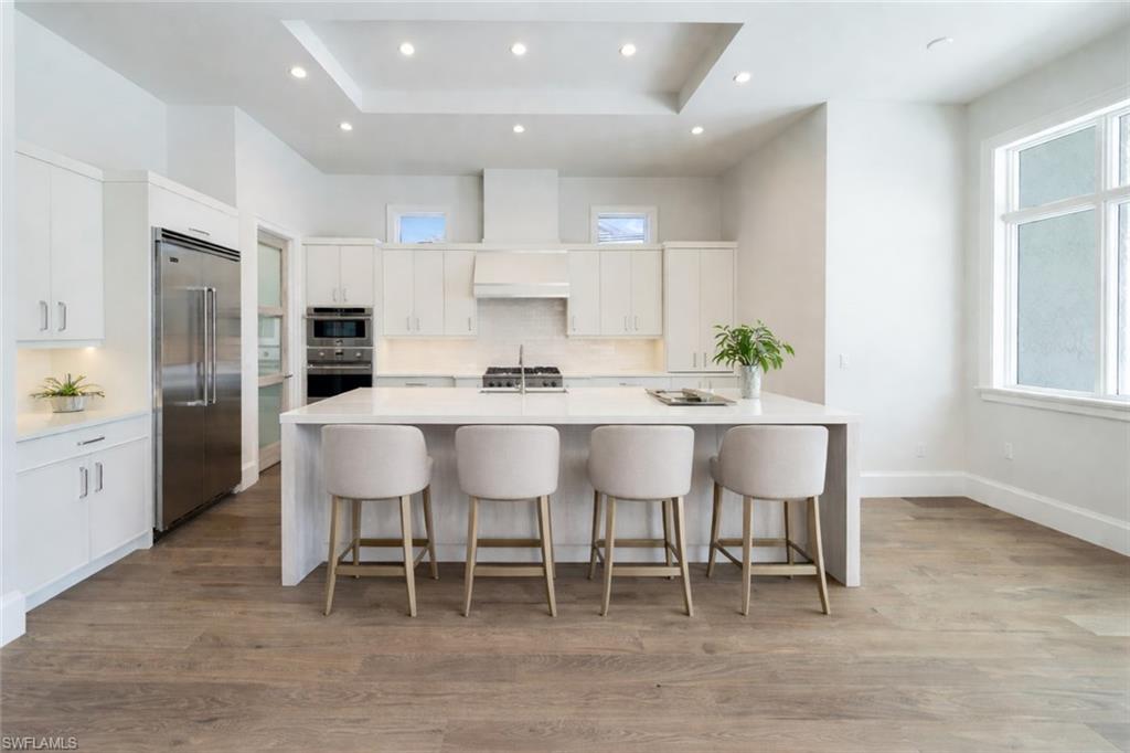 Kitchen featuring tasteful backsplash, a breakfast bar area, a large island, stainless steel appliances, and recessed lighting
