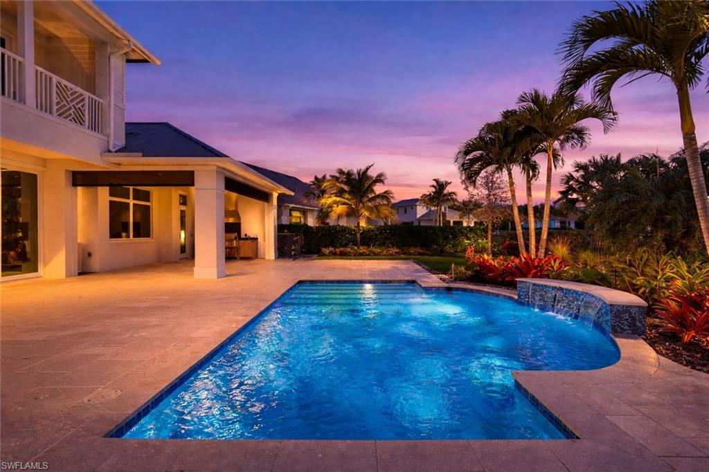 Pool at dusk with a patio and a balcony