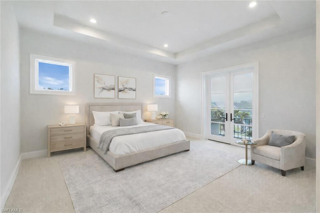 Bedroom featuring french doors, access to outside, light carpet, a tray ceiling, and recessed lighting