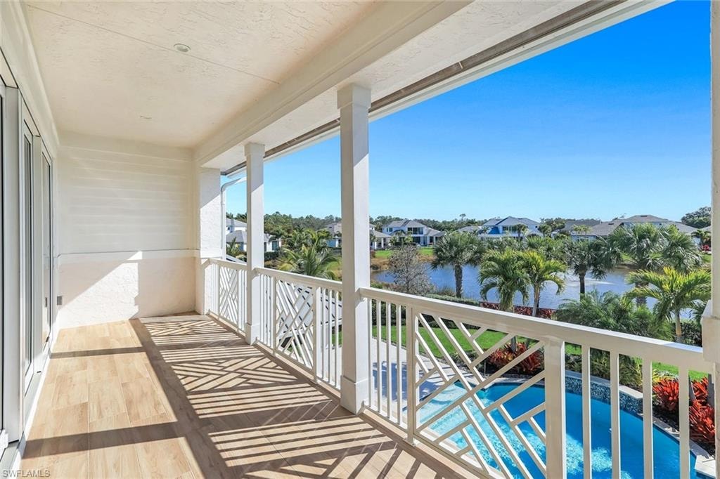 Balcony featuring view of pool, a residential view, and a water view