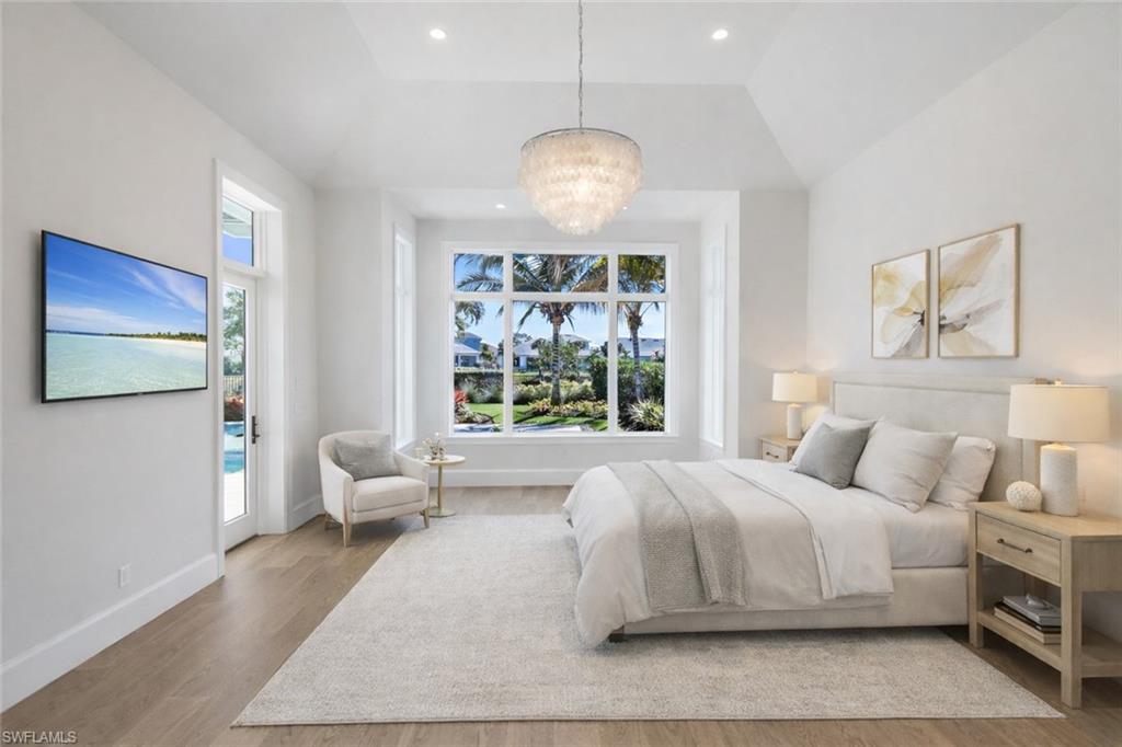Bedroom featuring access to outside, light wood-style flooring, suspended lighting, and vaulted ceiling