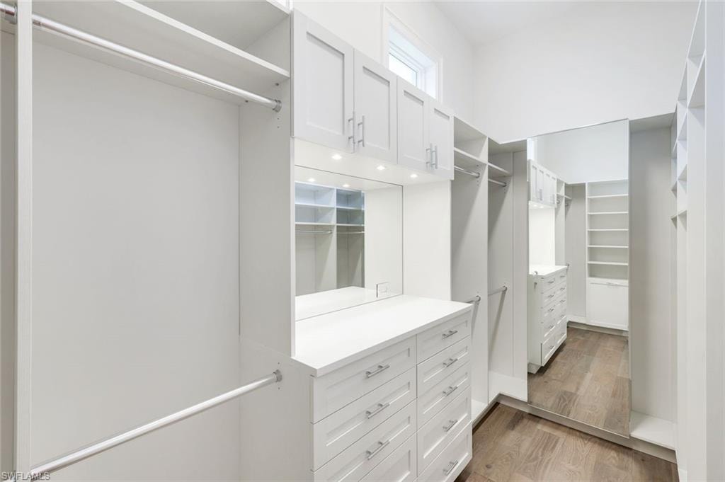 Walk in closet with light wood-type flooring