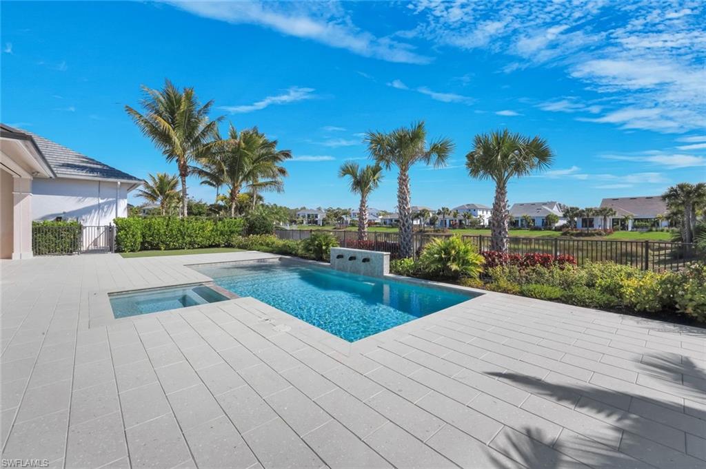Combined pool / hot tub featuring a fenced backyard, a residential view, and a patio area