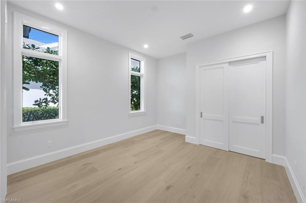 Unfurnished bedroom featuring light wood-type flooring, recessed lighting, and a closet
