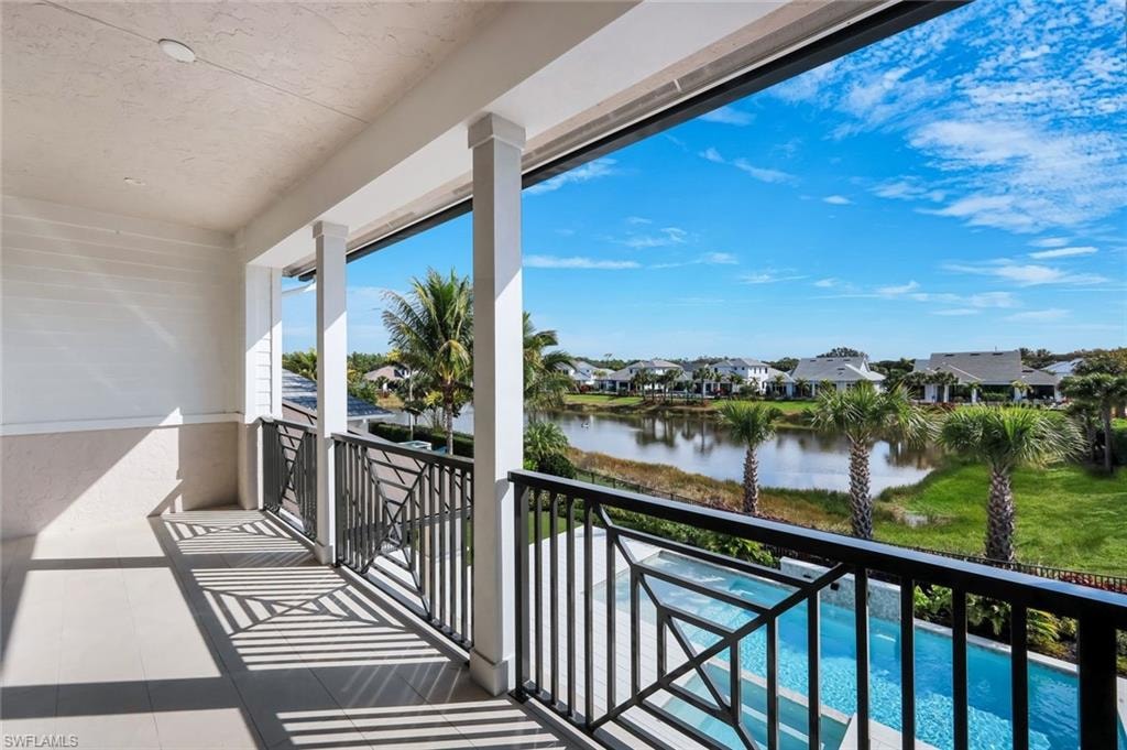 Balcony with view of pool area, a residential view, and a water view