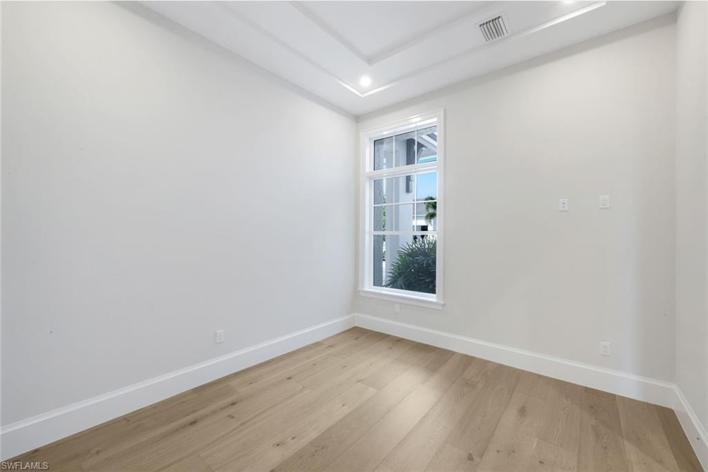 Unfurnished room featuring light wood finished floors and baseboards