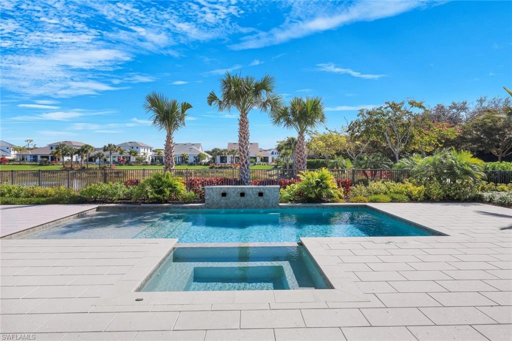 Combined pool / hot tub featuring a residential view, a fenced backyard, and a patio