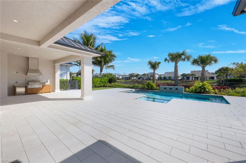 Integrated pool / spa featuring a patio, a residential view, area for grilling, and a fenced backyard