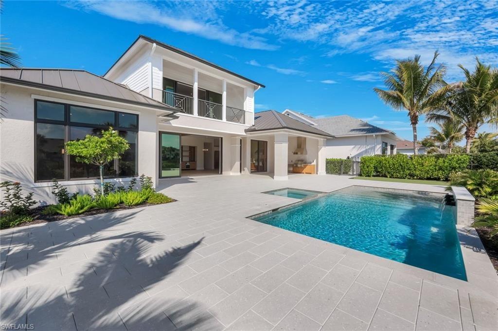 Integrated pool / spa with a balcony and a patio area