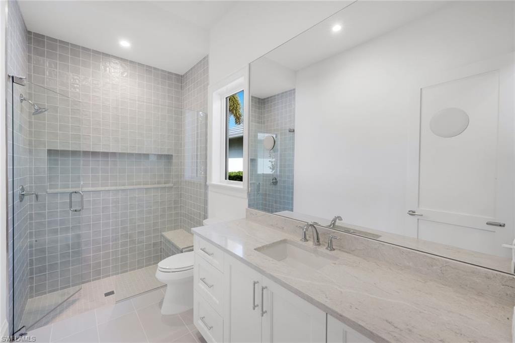 Full bath featuring vanity, light tile patterned floors, a shower stall, and recessed lighting