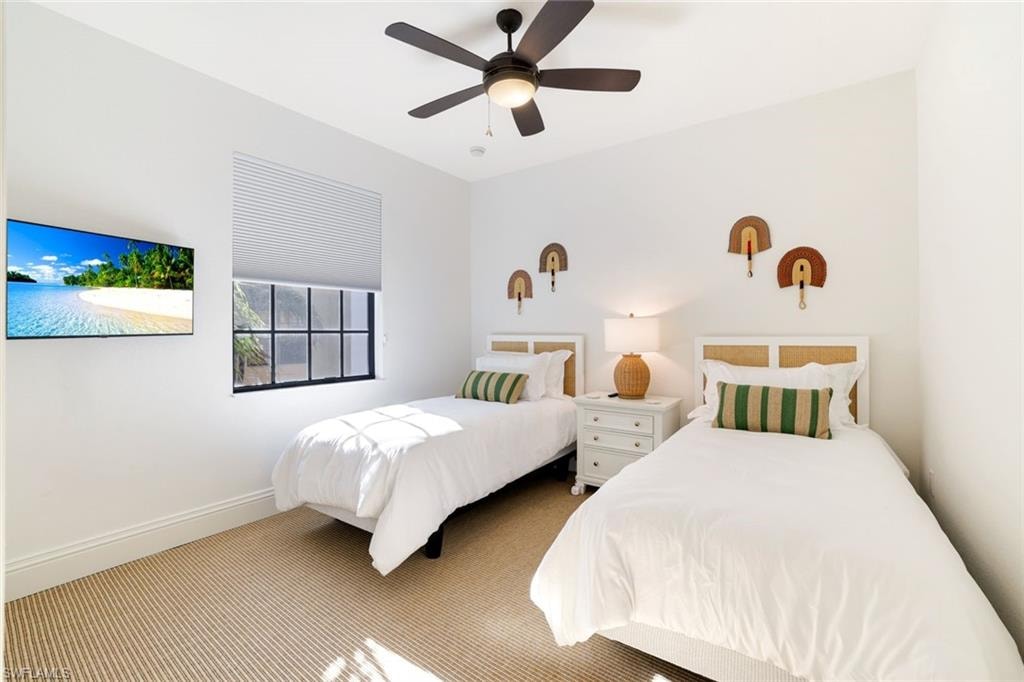 Carpeted bedroom with baseboards and ceiling fan