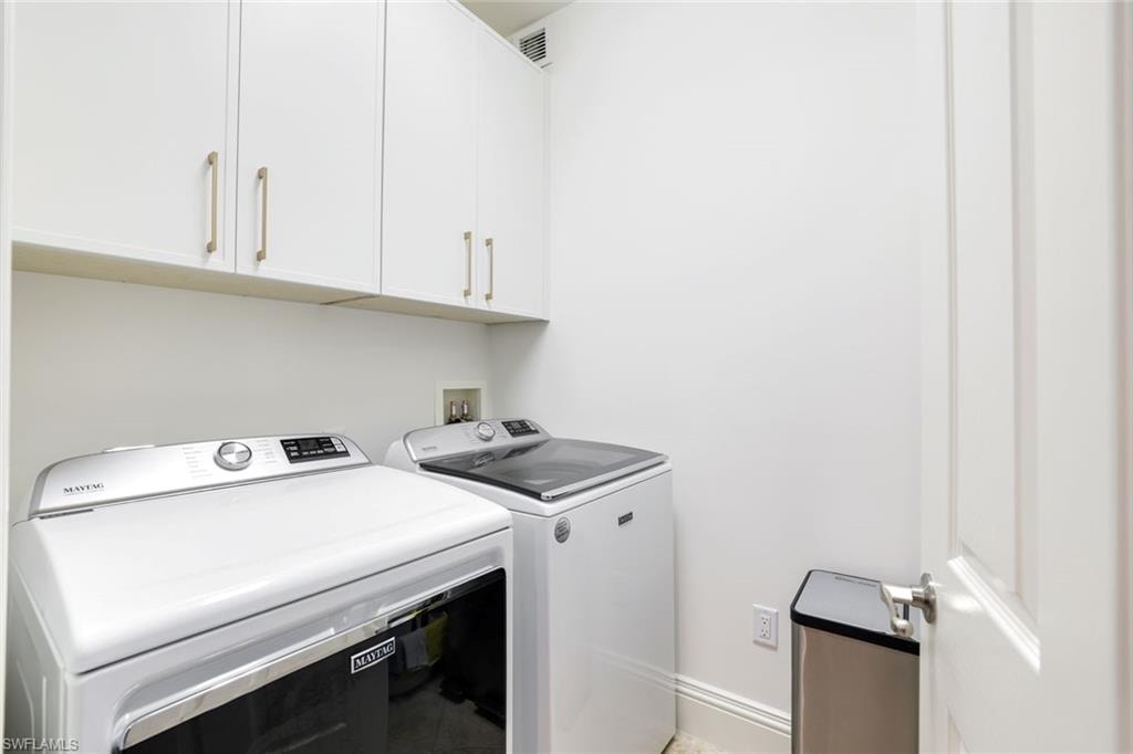Laundry room with separate washer and dryer and cabinet space
