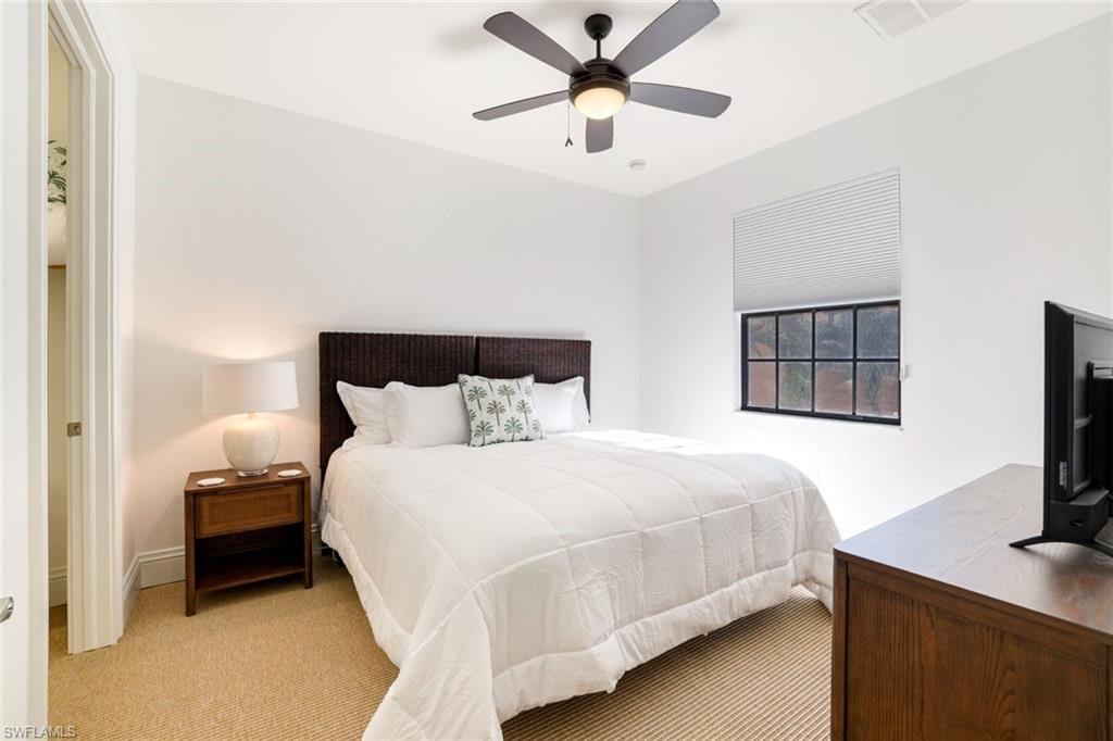 Bedroom with light carpet and a ceiling fan