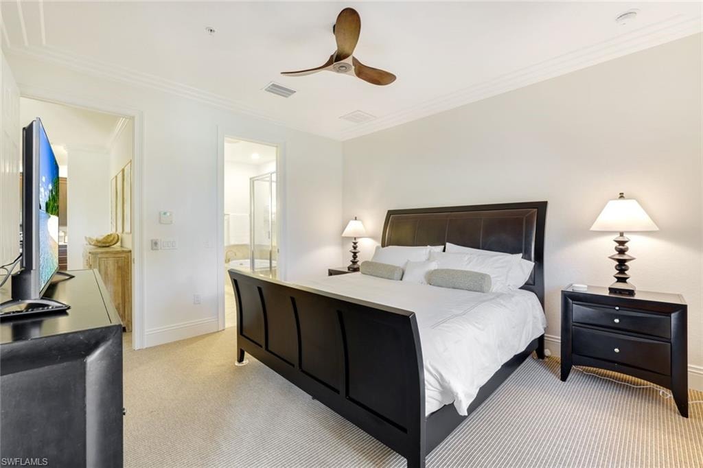 Bedroom with crown molding, light carpet, ceiling fan, and connected bathroom