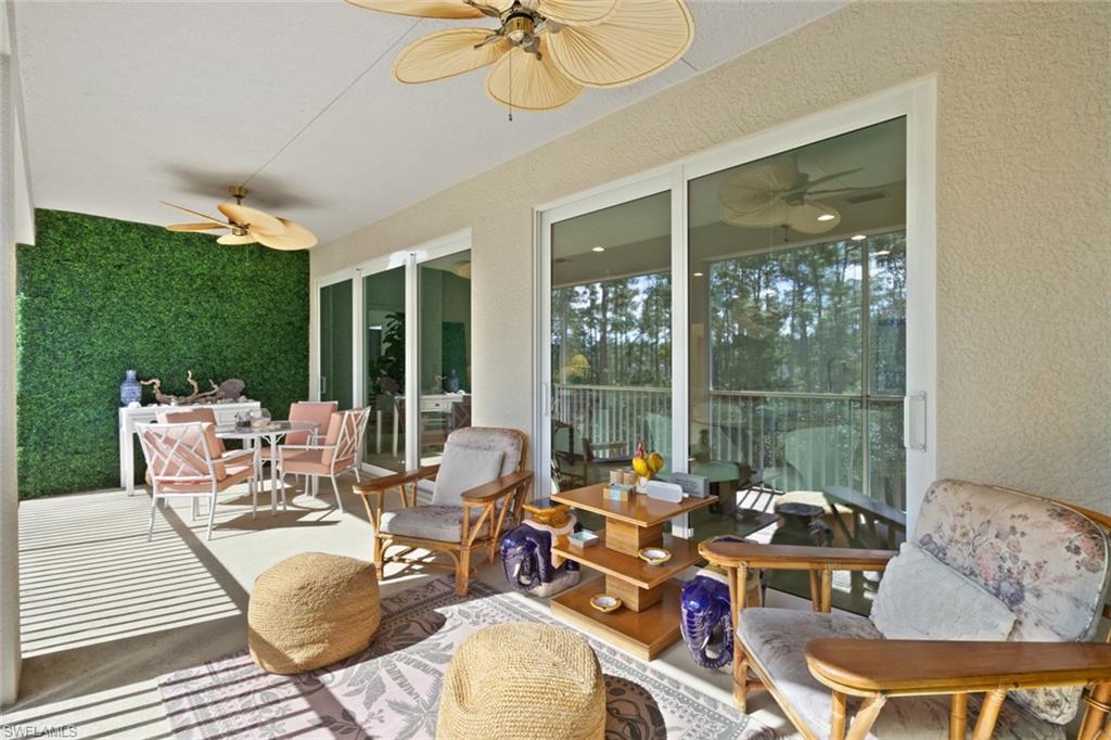 Sunroom featuring outdoor dining area, ceiling fan, and a patio