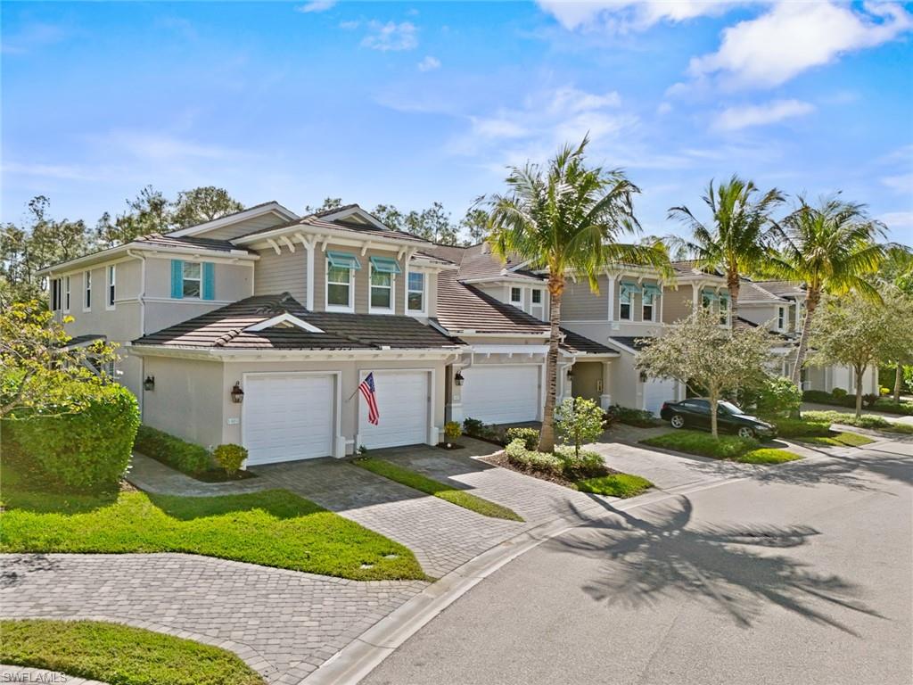 View of front of home with decorative driveway, a garage, a tile roof, and stucco siding